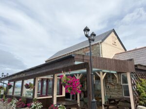 Exterior view of Smugglers Creek Inn Rossnowlagh with colorful flowers and Guinness sign