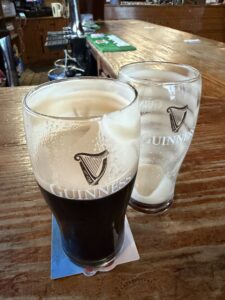 Two glasses of Guinness beer sitting on a wooden bar at the Market Bar in Manorhamilton