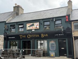 The Oyster Bar pub exterior with Guinness signage, food served notice, and live music on the facade