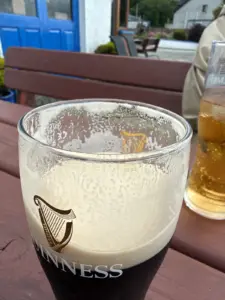 Salmon Inn Guinness, half empty, with lacing on the glass.