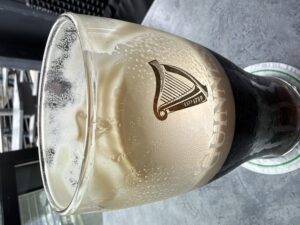 A Guinness in a half-empty clear pint glass
