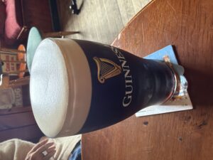 Guinness in a clear pint glass with a think foam head