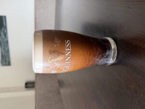 Guinnes in a pint glass on a wooden table