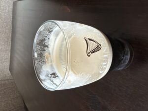 Guinness with rich creamy head and lacing on a dark wooden table