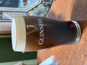 Guinness beer poured in a classic pint glass against wood background