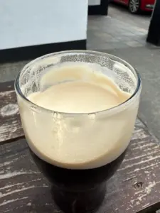A perfectly poured Guinness in a classic pint glass ready for tasting outside Phil Bans Pub