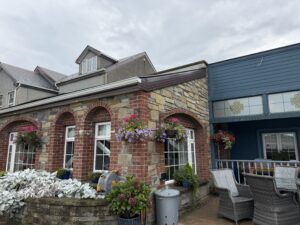 Wild Stag at Dulrush Lodge pub exterior with stone arches, hanging flowers, and patio seating