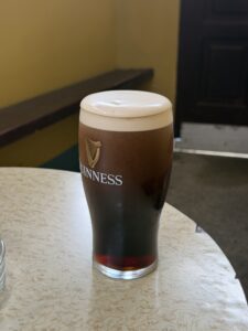 Brittons Bar Petigo Guinness pint with a creamy head on a table in a cozy pub interior