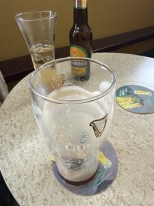 Brittons Bar Petigo Guinness pint on table with a half-finished glass and bottle in the background