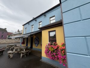Brittons Bar Petigo exterior with Guinness awning, flower box, and outdoor picnic tables
