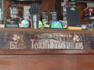 Teach Dixon pub interior bar with Guinness tap signage, Irish décor, and worn wooden counter details
