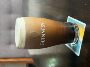Guinness pint at Teach Dixon pub on a table, with creamy head and dark stout in a cozy interior