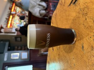 Guinness pint on a table at Molly’s Bar in Dunfanaghy, with cozy pub interior and bar background