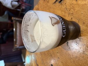 Guinness pint on a wooden table at Molly’s Bar in Dunfanaghy pub interior