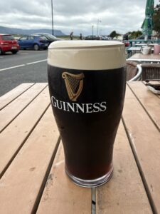 Pint of Guinness on a seaside pub table at Beach Hotel, Mullaghmore, with coastal mountain views