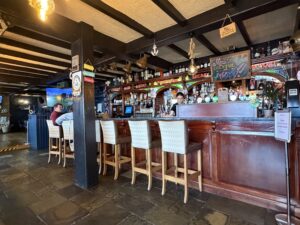 Cozy Beach Hotel bar interior in Mullaghmore, with Guinness taps, stools, and nautical decor